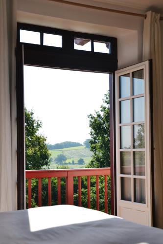 a bedroom with a bed and a large window at Chambres d'Hôtes Irazabala in Espelette