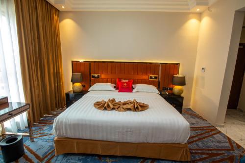 a hotel room with a large bed with a red pillow at Hôtel Fleur de Lys Point E in Dakar