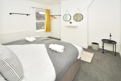 a bedroom with a bed with two towels on it at Keary House by YourStays, Stoke, with a touch of Scandinavia, 3 bedrooms, BOOK NOW! in Stoke on Trent