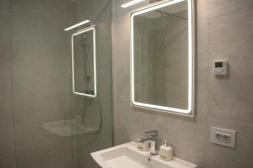 a bathroom with a sink and a shower with a mirror at Tampa View Kasper in Braşov