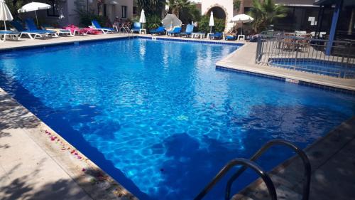 uma piscina com água azul num resort em Cozy 1 bedroom apartment close to the beach em Pafos