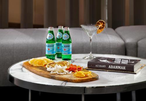 a table with a pizza and three bottles of soda at Wanda Vista Istanbul in Istanbul