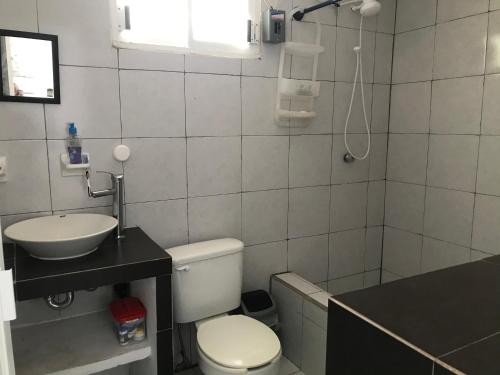 a bathroom with a toilet and a sink and a shower at La casa de la luna in Antón Lizardo