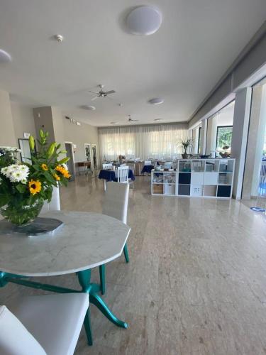 a room with a table with a vase of flowers on it at Hotel Maioli B&B in Misano Adriatico