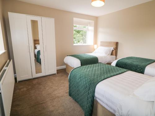 a hotel room with two beds and a mirror at Whitethorn House in Newry