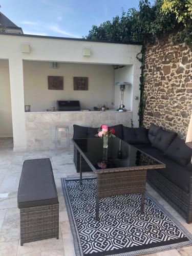 a living room with a couch and a table at Villa MY le Mans in Saint-Saturnin