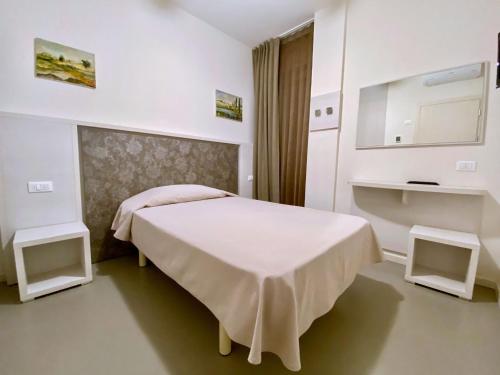 a white bedroom with a bed and a sink at Hotel Maioli B&B in Misano Adriatico