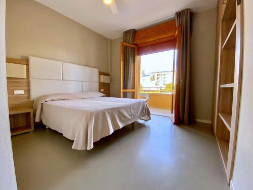 a bedroom with a bed and a large window at Hotel Maioli B&B in Misano Adriatico