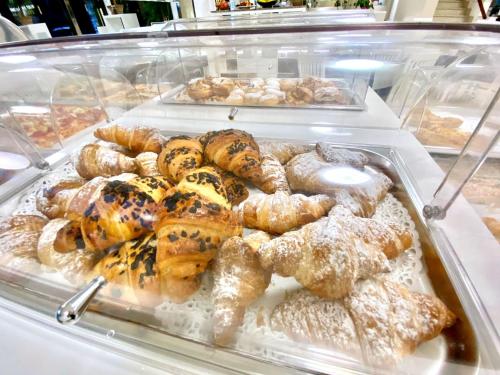 a display case filled with lots of pastries and donuts at Hotel Maioli B&B in Misano Adriatico