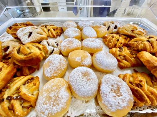 a bunch of donuts and pastries in a display case at Hotel Maioli B&B in Misano Adriatico