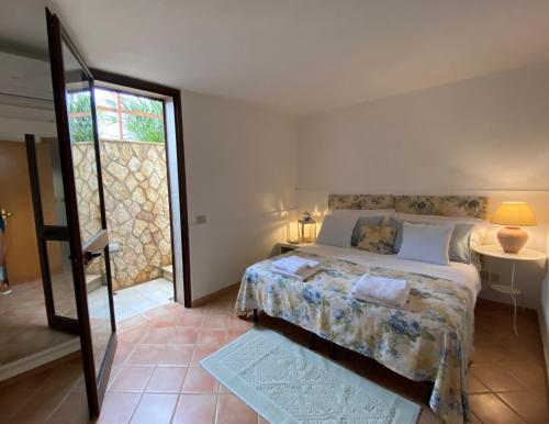 a bedroom with a bed and a table and a window at Villa Lisca Blu in Custonaci
