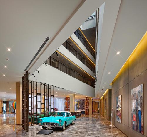 an old car sits in the middle of a lobby at Wanda Vista Istanbul in Istanbul