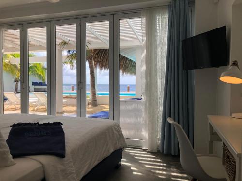 a bedroom with a bed and a view of the ocean at Beach House Pietermaai in Historic Pietermaai District in Willemstad
