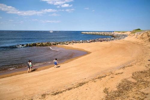 two people walking on a beach near the water at Plovers Nest in Newburyport