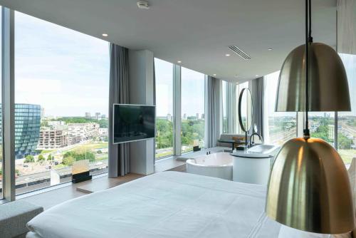 a bedroom with a large bed and a large window at Van der Valk Hotel Amsterdam Zuidas -Rai in Amsterdam