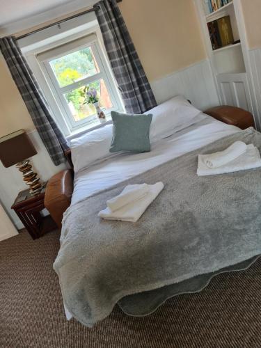 a bedroom with a large bed with a window at Ramblers Rest in Kirriemuir