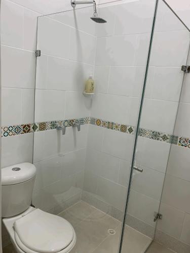 a bathroom with a toilet and a glass shower at Casa Grande in Medellín