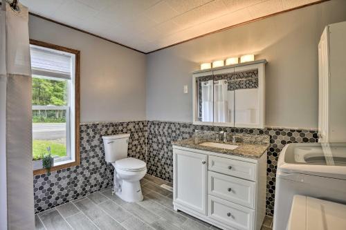 a bathroom with a toilet and a sink and a window at Altmar Family Home with Rivers and Trails Nearby! in Pulaski