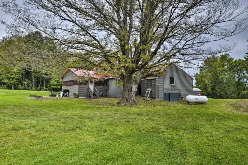 a house with a tree in a grass field at Altmar Family Home with Rivers and Trails Nearby! in Pulaski