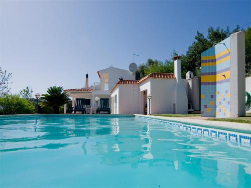 a swimming pool in front of a villa at Villa Oliandra in Vilamoura