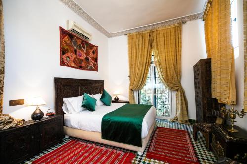 un dormitorio con una cama y una ventana en Dar Ben Daoud avec piscine et terrasse privee, en Fez