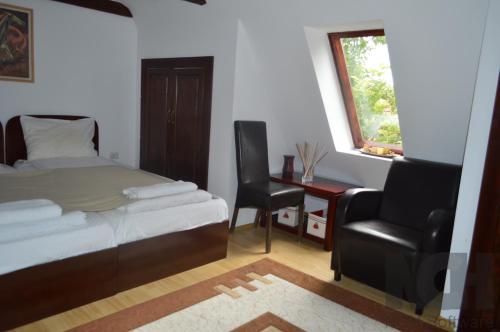 a bedroom with a bed and a chair and a desk at La Mos Pavel in Noşlac