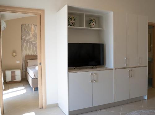 una sala de estar con TV en un armario blanco en Oasi Smart Rooms en Caltanissetta