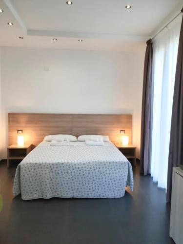 a bedroom with a white bed with two lamps and curtains at RipamontiBnB in Milan