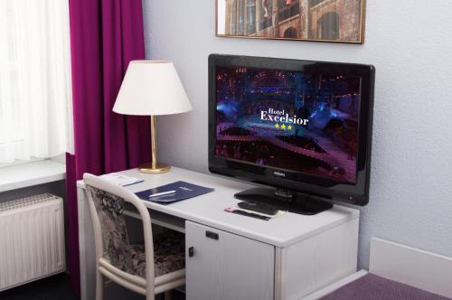 a tv sitting on a white desk with a lamp at Excelsior Bochum in Bochum