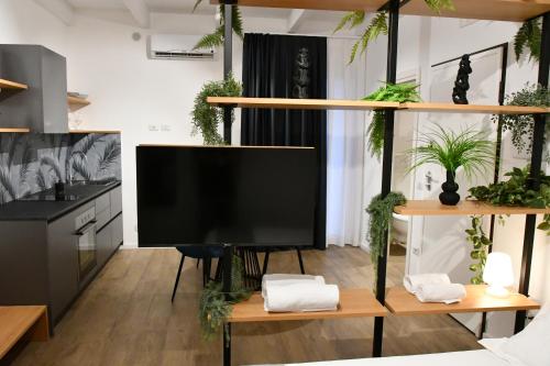 a living room with a flat screen tv on a table at Nu House Rooms & Apartments in Cassano delle Murge