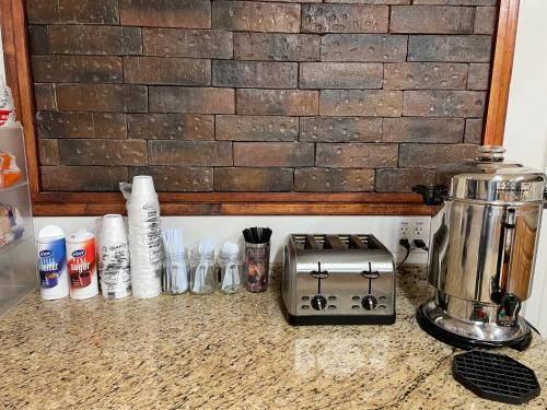 a kitchen counter with a toaster and other utensils at B&J HOTEL AND APARTMENTS in Pecos