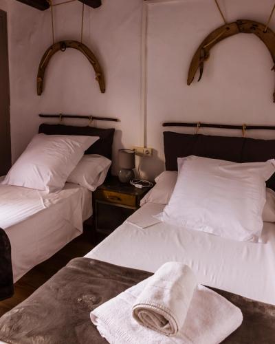 two beds in a room with white sheets and a towel at Casa Tato Figuerola d'Orcau in Figuerola de Orcau