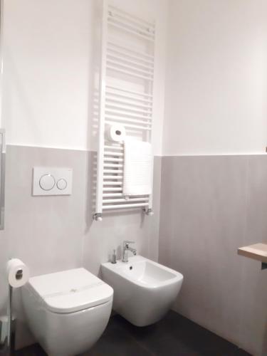 a white bathroom with a toilet and a sink at RipamontiBnB in Milan