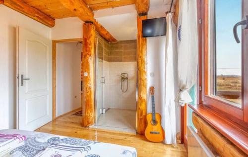 a bedroom with a shower and a guitar in a room at Wooden House Sveti Rok in Sveti Rok