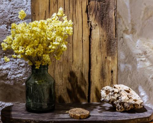 a vase of yellow flowers and a rock on a table at Casa Tato Figuerola d'Orcau in Figuerola de Orcau