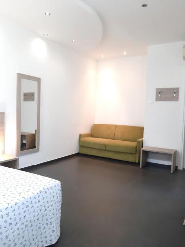 a white room with a couch and a mirror at RipamontiBnB in Milan