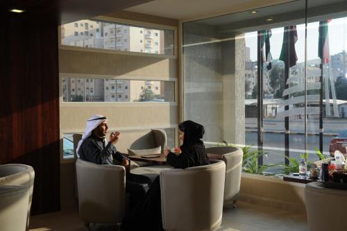 dos personas sentadas en una mesa en un restaurante en Salmiya Casa Hotel, en Kuwait