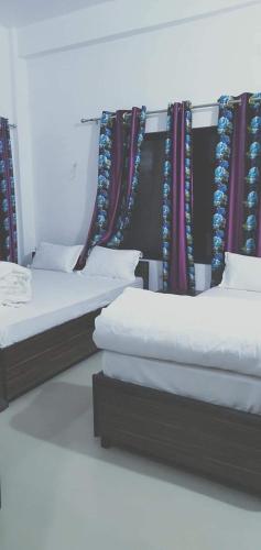 a row of beds in a room with curtains at Hotel Kanthak in Lumbini