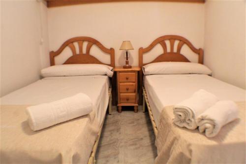 2 aparte bedden in een kamer met een nachtkastje bij RANCHOS 3-2 Levante Beach in Benidorm