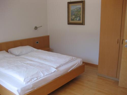 1 cama en un dormitorio con una foto en la pared en Ferienwohnung im Haus Texel IV, en Rablà