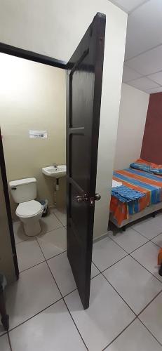 een badkamer met een toilet en een bed in een kamer bij Bosques del Tibet in Cerro Verde