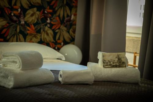 una pila de toallas y toallas en una cama en Elvas the Queen Residence, en Elvas