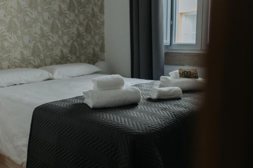 a bedroom with a bed with towels on it at Elvas the Queen Residence in Elvas
