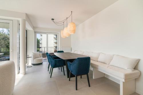 a dining room with a table and blue chairs at The Waves-Luxurious 3bedroom app w big terrace & garage in Ostend