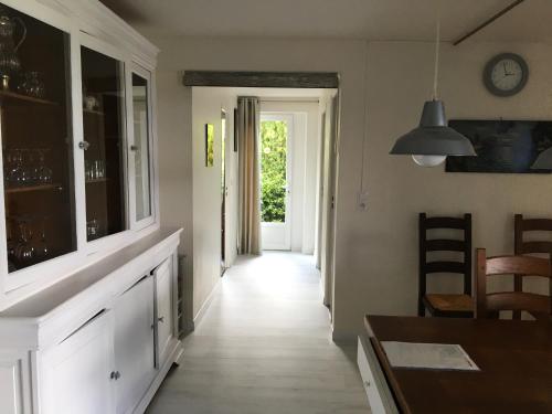 a kitchen with a long hallway with a table and chairs at Les Gîtes de La Maison Bleue d'Estialescq in Estialescq