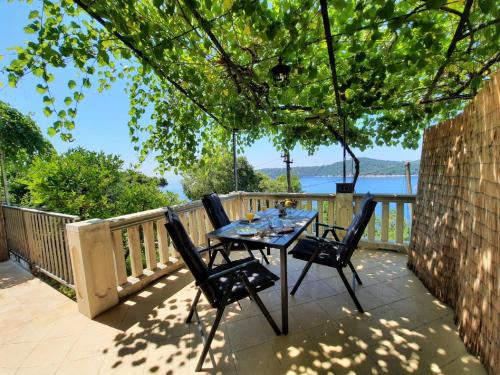 einen Tisch und Stühle auf einer Terrasse mit Blick auf das Wasser in der Unterkunft Apartments Kirigin in Dubrovnik