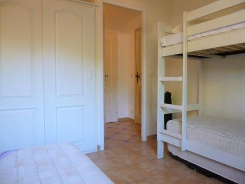 Cette chambre comprend 2 lits superposés et une porte. dans l'établissement Appartement 3 chambres climatisé dans Résidence calme avec Piscine et Tennis, à Cavalaire-sur-Mer