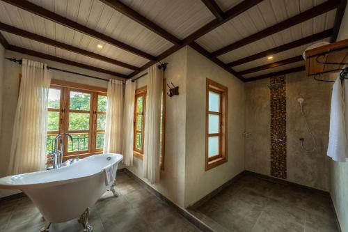 a large bathroom with a tub and a shower at Chimpundu Lodge in Fort Portal