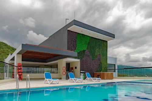 a building with a swimming pool and chairs next to it at VITA 945 in Gaira