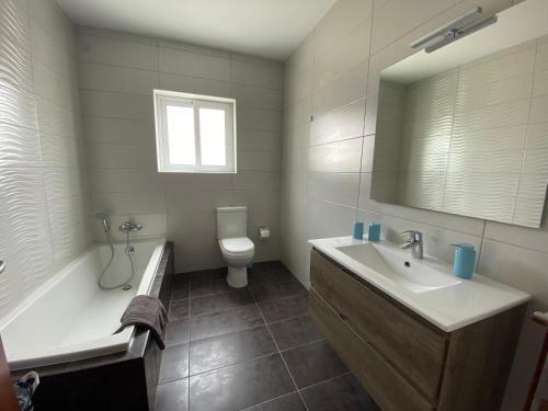 ein Badezimmer mit einem Waschbecken, einer Badewanne und einem WC in der Unterkunft Sunshine Apartments Mellieha - modern three bedroom ground floor apartment with yard in Mellieħa